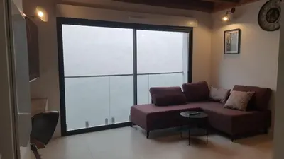 a living room with a couch and a large window at SUPERBE T3 AU COEUR DU CENTRE VILLE in Narbonne