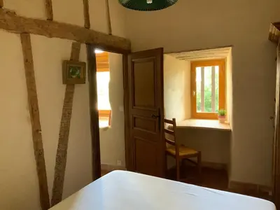 a bedroom with a door and a chair and a window at Château de Mézerville in Mézerville