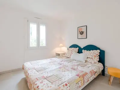 a white bedroom with a bed with a blue headboard at Pavillon lumineux avec terrasse, à 1 km de la plage – 2 pièces, 1 chambre, barbecue, Wi-Fi - FR-1-409A-3 in Gruissan