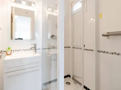 a white bathroom with a sink and a mirror at Pavillon lumineux avec terrasse, à 1 km de la plage – 2 pièces, 1 chambre, barbecue, Wi-Fi - FR-1-409A-3 in Gruissan