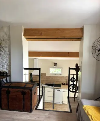 a room with a kitchen and a room with a table at Gite de charme à 10 min de Narbonne in Moussan