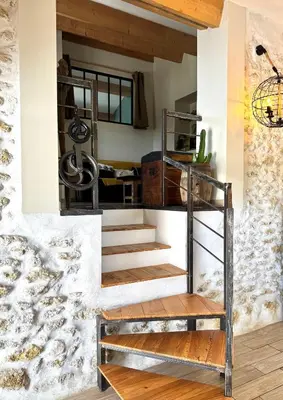 a staircase leading up to a room with a stone wall at Gite de charme à 10 min de Narbonne in Moussan