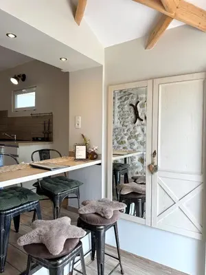 a dining room with a table and stools at Gite de charme à 10 min de Narbonne in Moussan