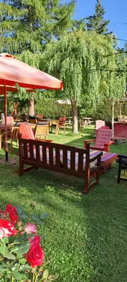 a park with benches and an umbrella and flowers at Cabane randonneur au camping in Camurac