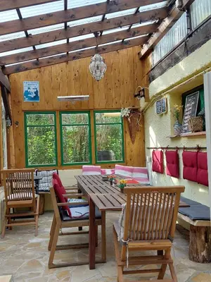 a living room with a wooden table and chairs at Cabane randonneur au camping in Camurac