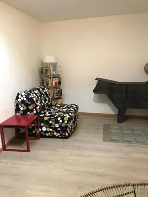 a living room with a couch and a chair at Le grenier de Manée in Villemoustaussou