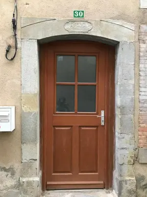 a brown door with a sign on top of it at Le grenier de Manée in Villemoustaussou