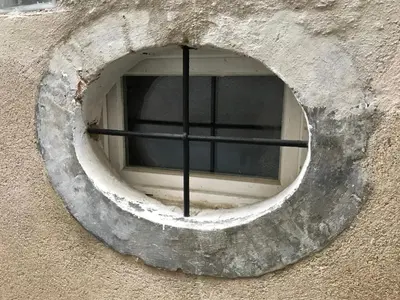 a round window in the side of a building at Le grenier de Manée in Villemoustaussou
