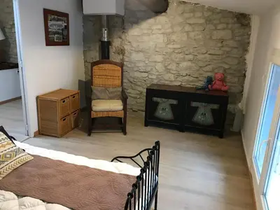 a room with two beds and a table and a chair at Le grenier de Manée in Villemoustaussou