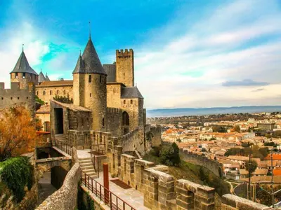 a castle on a hill with a city in the background at res La Barbacane, Carcassonne, studio for 2 people in Carcassonne