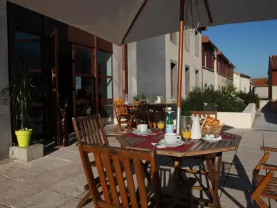a wooden table with an umbrella on a patio at res La Barbacane, Carcassonne, studio for 2 people in Carcassonne