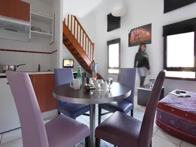 a dining room with a table and chairs and a woman at res La Barbacane, Carcassonne, studio for 2 people in Carcassonne