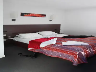 a bedroom with a bed with a red and white blanket at Res La Barbacane, Carcassonne, apartment for 4 pers in Carcassonne