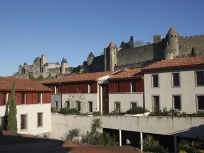 a group of buildings with a castle in the background at Res La Barbacane, Carcassonne, apartment for 4 pers in Carcassonne
