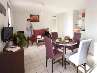 a living room with a table and purple chairs at Res La Barbacane, Carcassonne, apartment for 4 pers in Carcassonne