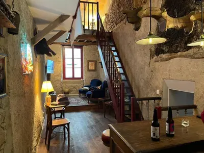 a room with a staircase and a living room at La Maison de Mama C: Charming french village home in Sainte-Colombe-sur-lʼHers