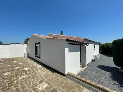 a white house with a stone driveway at Modern Comfort in Minervois in Pouzols-Minervois