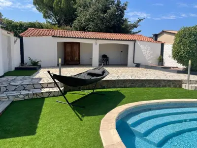a hammock in a yard next to a swimming pool at Modern Comfort in Minervois in Pouzols-Minervois