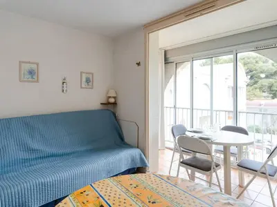 a bedroom with a bed and a table and chairs at Appartement à Gruissan avec Piscine - 4 Pers. - FR-1-409A-8 in Narbonne