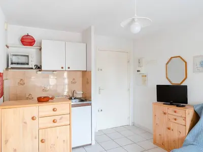 a kitchen with white cabinets and a sink and a microwave at Appartement à Gruissan avec Piscine - 4 Pers. - FR-1-409A-8 in Narbonne