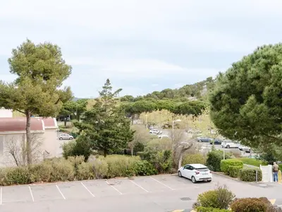 a white car parked in a parking lot at Appartement à Gruissan avec Piscine - 4 Pers. - FR-1-409A-8 in Narbonne