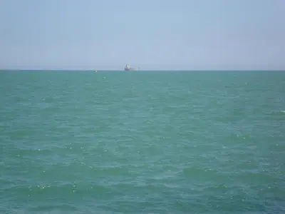 a large body of water with a ship in the distance at Mobilhome « Candice » in Sigean