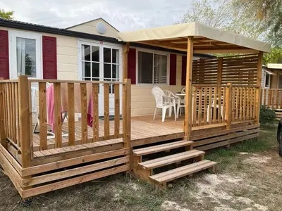 a wooden deck with a gazebo at Mobilhome « Candice » in Sigean