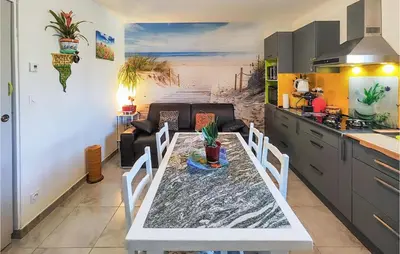 a living room with a table and a kitchen at 1 Bedroom Gorgeous Home In Capestang in Capestang