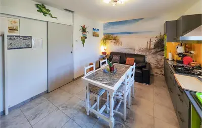 a kitchen with a white table and chairs in a room at 1 Bedroom Gorgeous Home In Capestang in Capestang