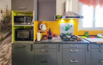 a kitchen with a stove and a microwave at 1 Bedroom Gorgeous Home In Capestang in Capestang