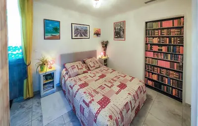 a bedroom with a bed and a book shelf with books at 1 Bedroom Gorgeous Home In Capestang in Capestang