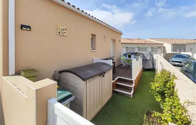 a backyard with a wooden deck and a water heater at 1 Bedroom Gorgeous Home In Capestang in Capestang