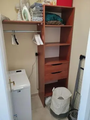 a closet with a wooden shelf next to a toilet at Charmant T2 moderne au calme avec jardin vue sur Canigou in Molitg les Bains