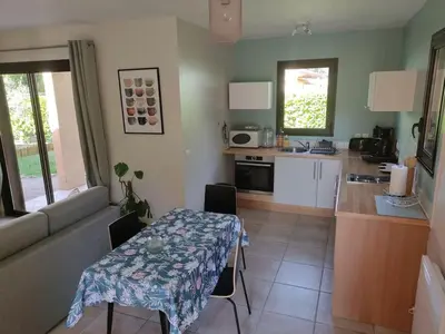 a kitchen with a table and a kitchen with a table and chairs at Charmant T2 moderne au calme avec jardin vue sur Canigou in Molitg les Bains