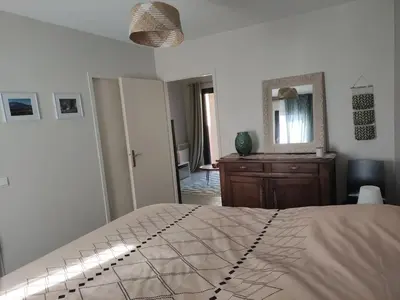 a bedroom with a bed with a mirror and a dresser at Charmant T2 moderne au calme avec jardin vue sur Canigou in Molitg les Bains