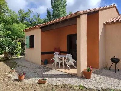a small house with a patio with a table and chairs at Charmant T2 moderne au calme avec jardin vue sur Canigou in Molitg les Bains