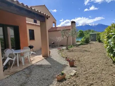 a patio of a house with a table and chairs at Charmant T2 moderne au calme avec jardin vue sur Canigou in Molitg les Bains