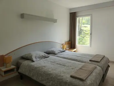 a bedroom with a bed with two pillows and a window at Evasion en pays Cathare in Quillan