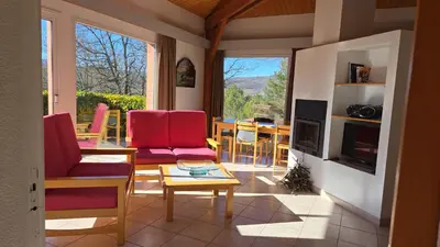 a living room with red chairs and a table at Evasion en pays Cathare in Quillan