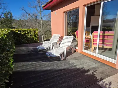 three white chairs sitting on a deck next to a house at Evasion en pays Cathare in Quillan
