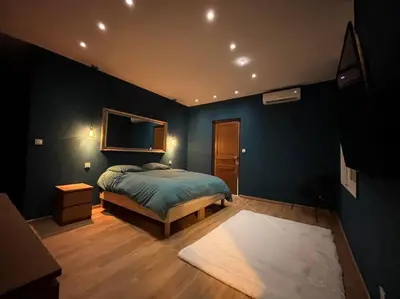 a bedroom with a bed and a blue wall at Appartement Haussmannien a 200m des Halles. in Narbonne