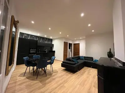 a living room with a couch and a table and chairs at Appartement Haussmannien a 200m des Halles. in Narbonne