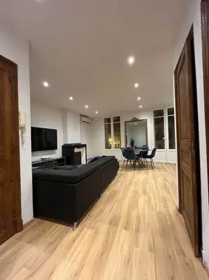 a large living room with a bed and a table at Appartement Haussmannien a 200m des Halles. in Narbonne