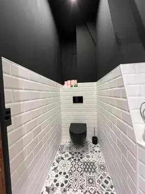a bathroom with a black toilet and a tiled floor at Appartement Haussmannien a 200m des Halles. in Narbonne