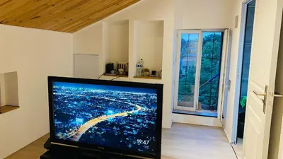 a flat screen tv sitting in a living room with a window at Studio Cros climatisé in Castres