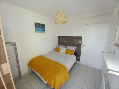a bedroom with a bed with a yellow blanket at Appart 2/4 pers proche centre avec Balcon, Parking in Narbonne
