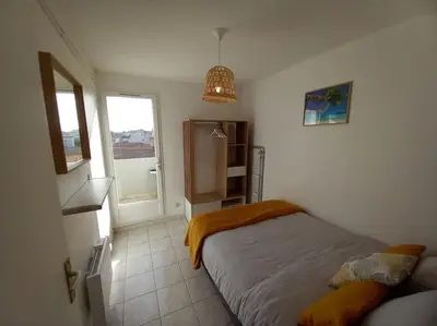 a small bedroom with a bed and a window at Appart 2/4 pers proche centre avec Balcon, Parking in Narbonne
