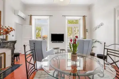 a living room with a glass table and chairs at Appartement avec balcon, bord du canal, Wifi. in Narbonne