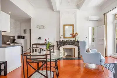 a living room with a table and a fireplace at Appartement avec balcon, bord du canal, Wifi. in Narbonne