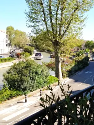 a view from a balcony of a street with a tree at Appartement avec balcon, bord du canal, Wifi. in Narbonne
